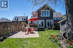 Back of property with a fenced backyard, a patio, and a wooden deck - 