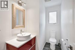 Half bath featuring vanity and dark wood-style floors - 