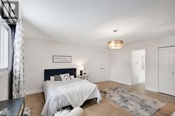 Bedroom with wood finished floors, a textured ceiling, and a closet - 