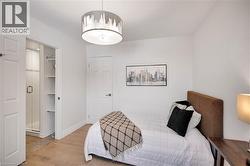 Bedroom featuring wood finished floors and a walk in closet - 