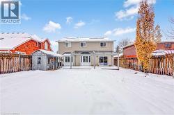 Snow covered house featuring a fenced backyard, solar panels, and an outdoor structure - 