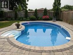View of swimming pool featuring a fenced backyard and a patio area - 