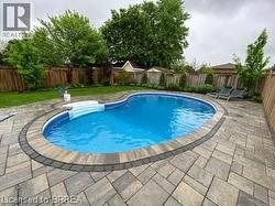 View of pool with a fenced backyard and a patio area - 