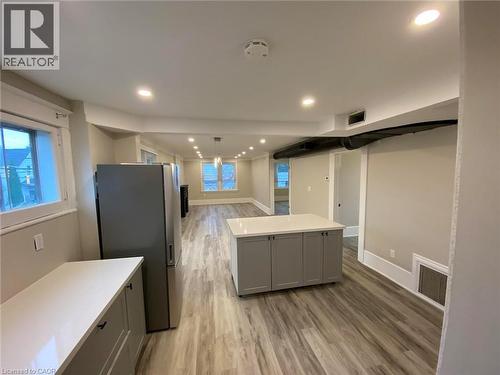 Kitchen featuring gray cabinetry, freestanding refrigerator, light wood-style floors, a center island, and hanging light fixtures - 193 Balmoral Avenue N, Hamilton, ON - Indoor Photo Showing Kitchen