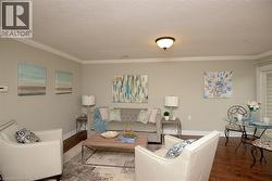 Living room with wood finished floors, crown molding, and a textured ceiling - 