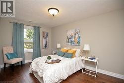 Bedroom with a textured ceiling and dark wood finished floors - 