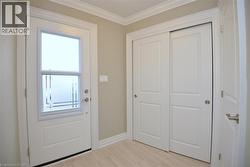Doorway to outside with ornamental molding and wood finished floors - 