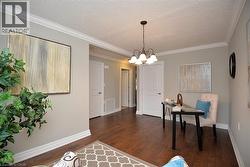 Home office with crown molding, a textured ceiling, dark wood finished floors, and a chandelier - 