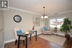 Home office featuring crown molding, dark wood-style floors, a textured ceiling, and a chandelier - 