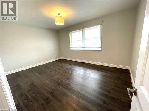Spare room featuring dark wood-style flooring and baseboards - 557 Lake Street, St. Catharines, ON - Indoor Photo Showing Other Room