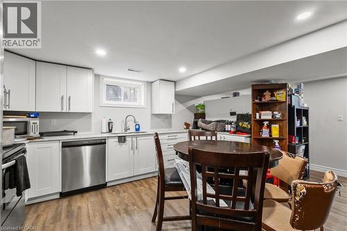 Kitchen with appliances with stainless steel finishes, white cabinetry, light wood-style floors, light stone counters, and open floor plan - 557 Lake Street, St. Catharines, ON - Indoor Photo Showing Kitchen