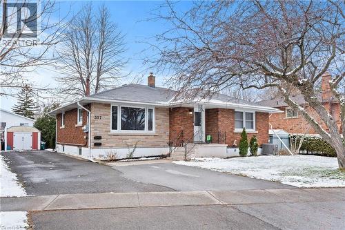 View of front facade with a chimney, brick siding, a storage unit, and stone siding - 557 Lake Street, St. Catharines, ON - Outdoor With Facade