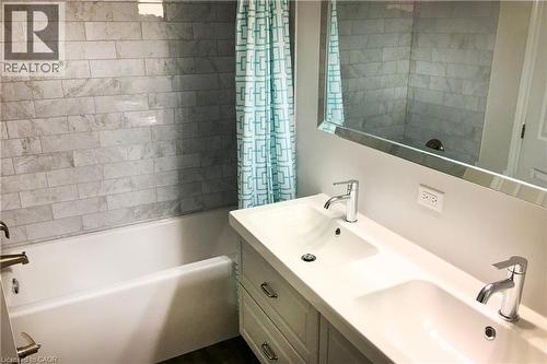 Full bath featuring double vanity and shower / bath combo with shower curtain - 557 Lake Street, St. Catharines, ON - Indoor Photo Showing Bathroom