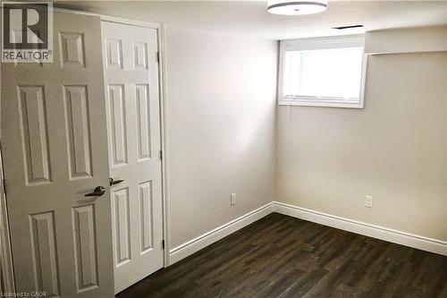 Unfurnished bedroom with dark wood-type flooring and baseboards - 557 Lake Street, St. Catharines, ON - Indoor Photo Showing Other Room