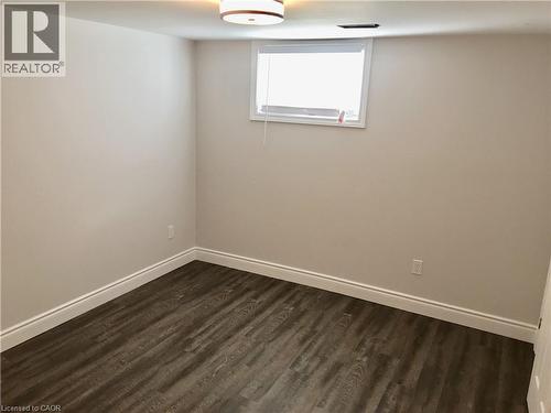 Spare room featuring dark wood-type flooring and baseboards - 557 Lake Street, St. Catharines, ON - Indoor Photo Showing Other Room