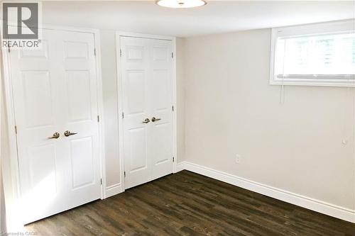 Unfurnished bedroom with multiple closets and dark wood-type flooring - 557 Lake Street, St. Catharines, ON - Indoor Photo Showing Other Room