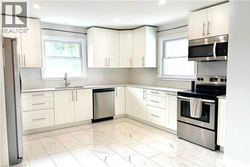 Kitchen featuring appliances with stainless steel finishes, light marble finish flooring, white cabinets, plenty of natural light, and recessed lighting - 557 Lake Street, St. Catharines, ON - Indoor Photo Showing Kitchen With Upgraded Kitchen