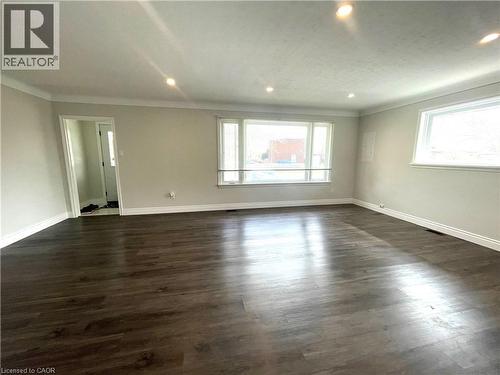 Unfurnished room featuring dark wood-style flooring, ornamental molding, and recessed lighting - 557 Lake Street, St. Catharines, ON - Indoor Photo Showing Other Room