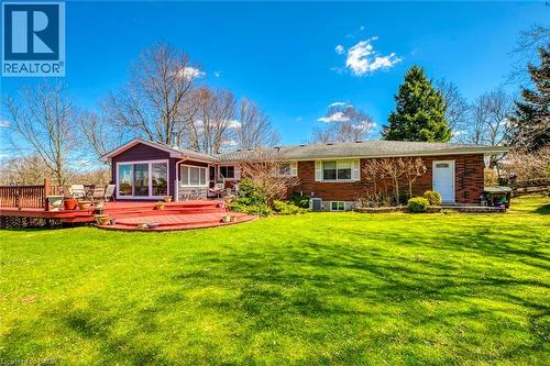Rear view of property with a wooden deck, brick siding, and a yard - 1215 Britannia Road, Burlington, ON 