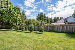Fenced backyard featuring view of wooded area - 