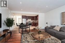 Living area with light wood-style flooring and recessed lighting - 