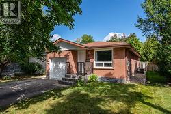 View of front of house featuring driveway, brick siding, and a garage - 