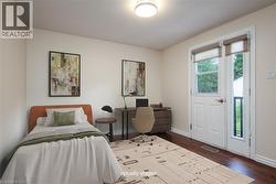 Bedroom with dark wood-style floors and an office area - 