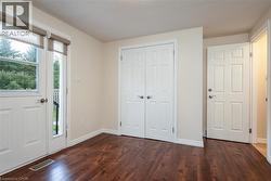 Foyer featuring dark wood-style flooring and baseboards - 