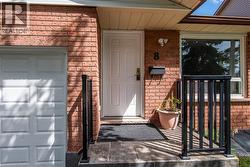 Doorway to property featuring brick siding and a porch - 