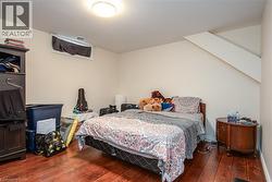 Bedroom featuring hardwood / wood-style floors and baseboards - 