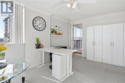 Office space featuring light colored carpet, crown molding, and ceiling fan - 