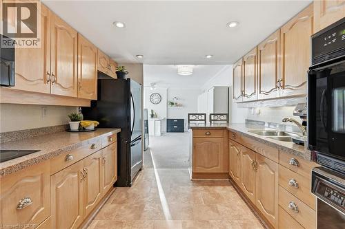 Kitchen with dark stone counters, black appliances, a peninsula, ornamental molding, and recessed lighting - 2170 Marine Drive Unit# 1808, Oakville, ON - Indoor Photo Showing Kitchen With Double Sink