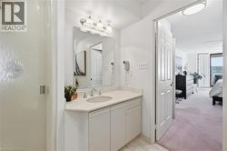 Ensuite bathroom featuring vanity, a shower stall, and light carpet - 