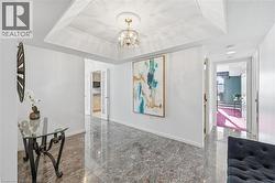 Hallway featuring a chandelier and granite floors - 