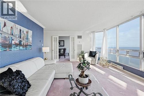 Carpeted living room featuring french doors, a textured ceiling, a water view, ornamental molding, and floor to ceiling windows - 2170 Marine Drive Unit# 1808, Oakville, ON - Indoor Photo Showing Living Room