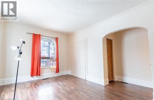 Spare room with dark wood-style floors, arched walkways, and crown molding - 219 Erie Avenue, Brantford, ON - Indoor Photo Showing Other Room