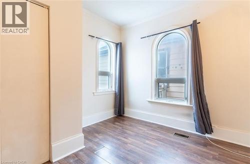 Empty room featuring dark wood-style floors and crown molding - 219 Erie Avenue, Brantford, ON - Indoor Photo Showing Other Room
