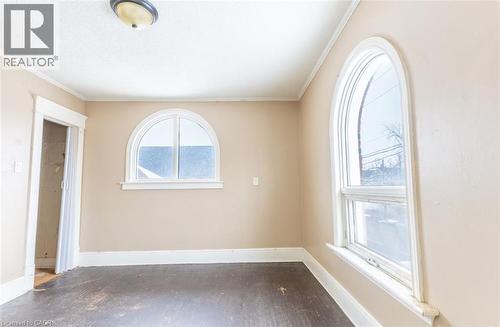 Spare room featuring dark wood-style flooring and ornamental molding - 219 Erie Avenue, Brantford, ON - Indoor Photo Showing Other Room