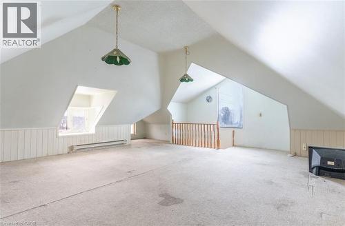 Additional living space featuring lofted ceiling, healthy amount of natural light, baseboard heating, and wainscoting - 219 Erie Avenue, Brantford, ON - Indoor Photo Showing Other Room