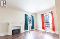 Unfurnished living room featuring a fireplace and dark wood-style flooring - 
