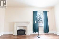 Unfurnished living room featuring wood finished floors and crown molding - 