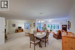 Dining room featuring carpet, a chandelier, and a ceiling fan - 