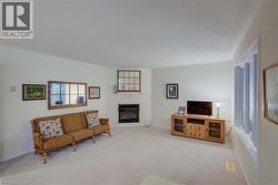 Living room featuring carpet flooring and a glass covered fireplace - 