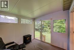 Sunroom / solarium featuring a wood stove and lofted ceiling - 