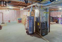 Unfinished basement featuring heating unit, water heater, and drainage system - 