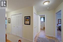 Hallway with light colored carpet and baseboards - 