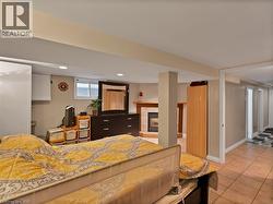 Bedroom featuring a tile fireplace, light tile patterned floors, and recessed lighting - 