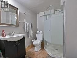 Bathroom featuring vanity, a shower stall, and light tile patterned flooring - 