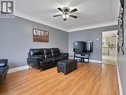 Living room featuring light wood finished floors and a ceiling fan - 