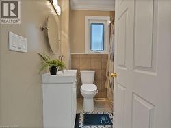 Bathroom featuring tile patterned floors, vanity, tile walls, and crown molding - 